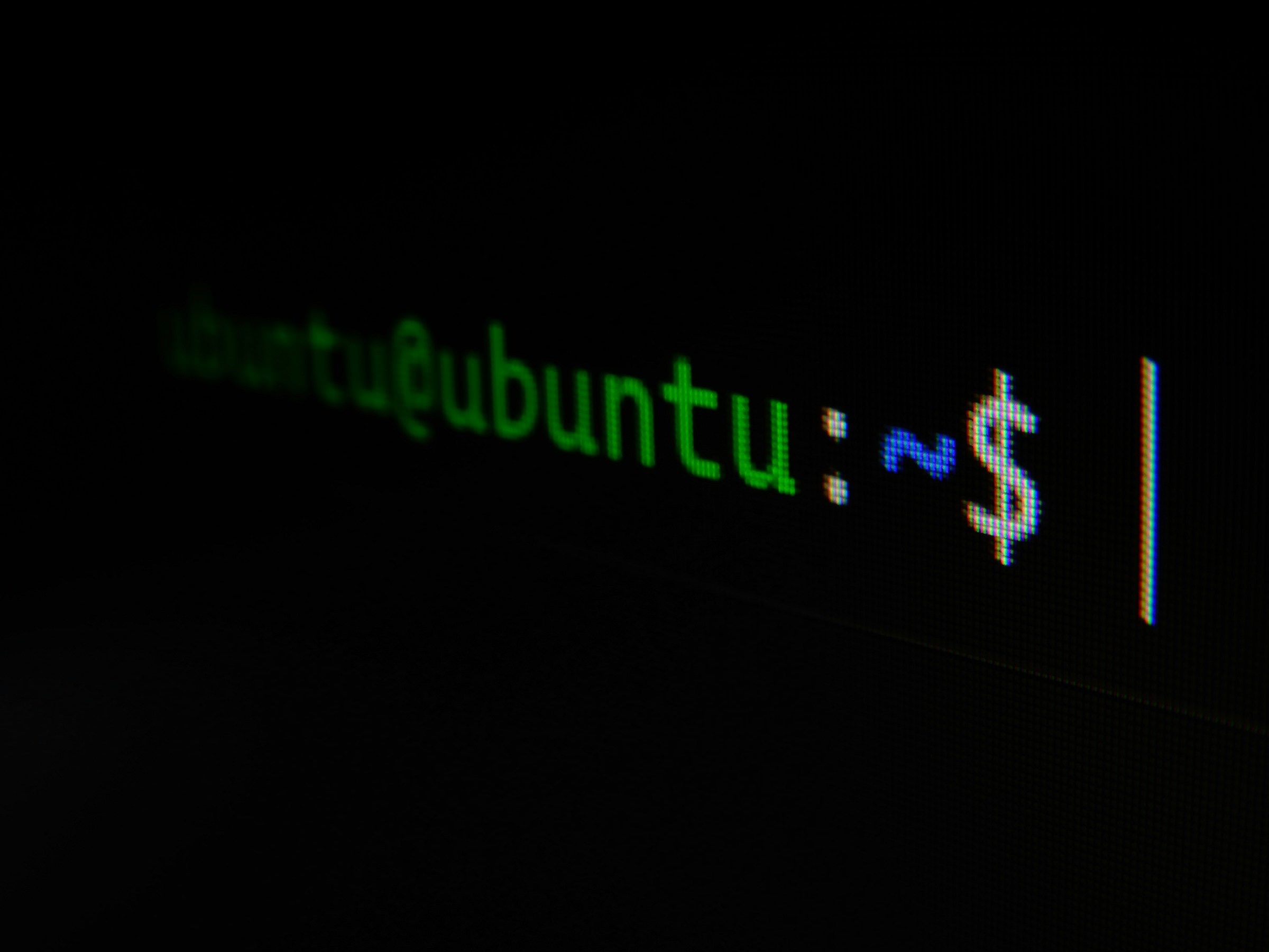 Close-up of a green 'ubuntu:~$' shell prompt rendered on a dark terminal screen, the pixel grid of the display visible at the shooting angle. A visual stand-in for the early-2000s Linux era this post recalls; the actual subject was Mandrake Linux 9.1.